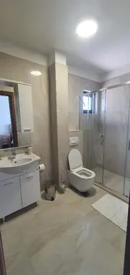 a bathroom with a shower and a toilet and a sink at Hotel Svarog in Becici