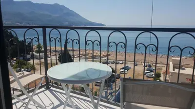 a balcony with a table and a view of a beach at Hotel Svarog in Becici