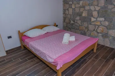 a bedroom with a bed with two towels on it at Leonida Resort in Donji Štoj