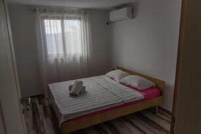 a small bedroom with a bed and a window at Leonida Resort in Donji Štoj