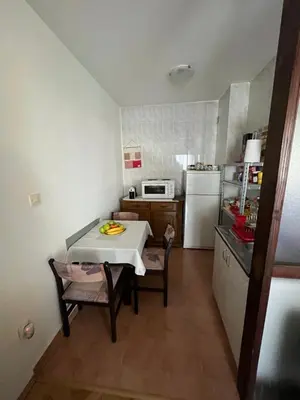 a small kitchen with a white table and a white refrigerator at 