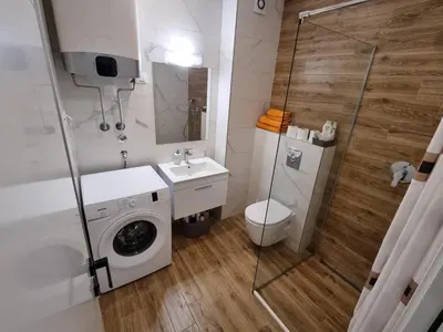 a bathroom with a washing machine and a sink at Stan na dan Podgorica in Podgorica