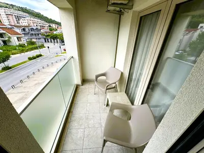 a balcony with two chairs and a table and a window at Stan na dan Podgorica in Podgorica