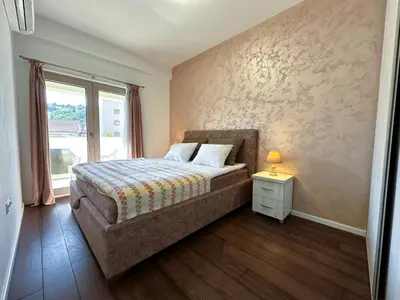 a bedroom with a bed and a window at Stan na dan Podgorica in Podgorica