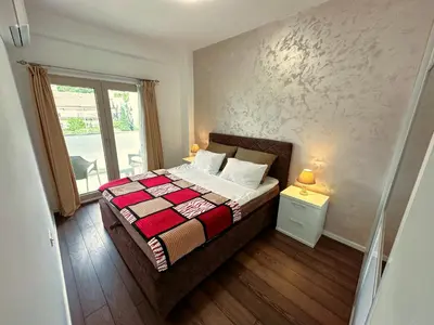 a small bedroom with a bed and a window at Stan na dan Podgorica in Podgorica