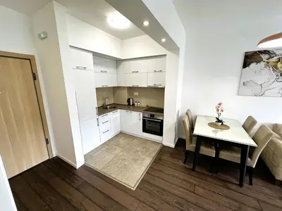 a living room with a table and a kitchen at Stan na dan Podgorica in Podgorica