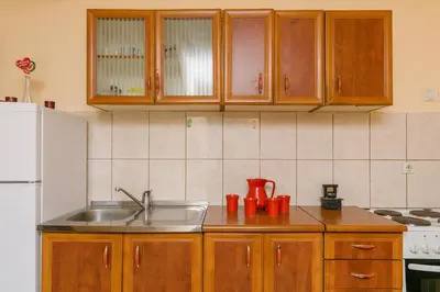 a kitchen with a sink and a white refrigerator at Apartments Feniks in Kotor