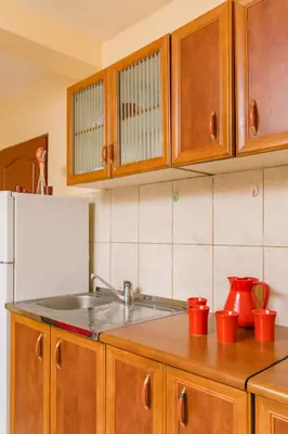 a kitchen with a sink and a white refrigerator at Apartments Feniks in Kotor