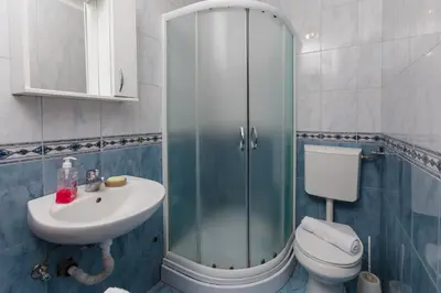 a bathroom with a shower and a toilet and a sink at Apartments Feniks in Kotor