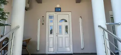 a white door with a blue sign on top of it at Apartment's Meti in Ulcinj