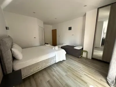 a small bedroom with a bed and a mirror at Apartment's Meti in Ulcinj