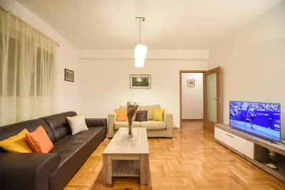 a living room with a couch and a tv at Enigma in Podgorica