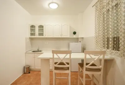 a kitchen with a table and two stools at Enigma in Podgorica