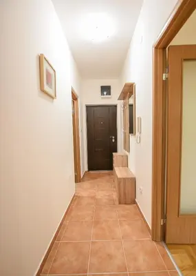 a hallway with a door and a tiled floor at Enigma in Podgorica