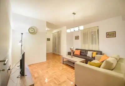 a living room with a couch and a tv at Enigma in Podgorica