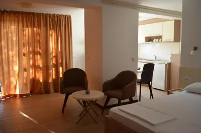 a bedroom with a bed and two chairs and a table at Apartments TMV Dragovic in Sveti Stefan