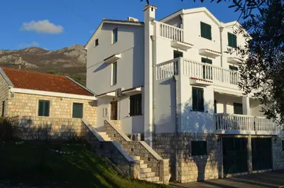 a white house with stairs in front of it at Apartments TMV Dragovic in Sveti Stefan