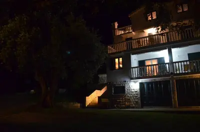 a large building with lights on at night at Apartments TMV Dragovic in Sveti Stefan