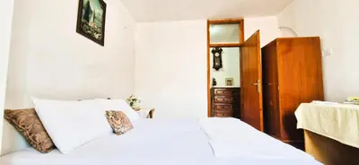 a bedroom with a white bed and a wooden door at Biuk in Kotor