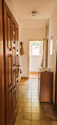 a kitchen with a tiled floor and a hallway with a door at Biuk in Kotor