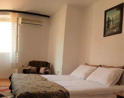 a bedroom with a bed and a chair in it at Biuk in Kotor
