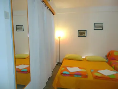 a small bedroom with two beds and a mirror at Apartments Villa Petranović in Budva