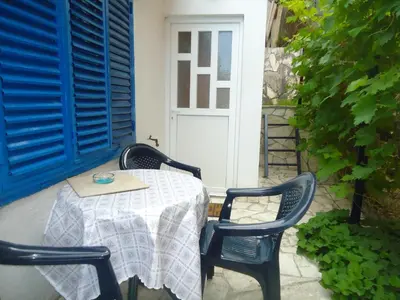 a table and chairs on a patio with a door at Apartments Villa Petranović in Budva