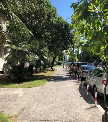 a sidewalk with cars parked on the side of a street at Cicki Apartments II in Podgorica