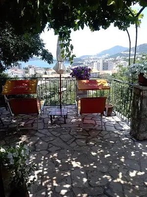 a patio with a table and chairs and an umbrella at Apartments Villa Čučuk in Budva