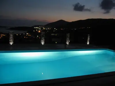 a swimming pool at night with a city at Apartments Villa Čučuk in Budva
