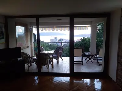 a living room with a sliding glass door with a table and chairs at Apartments Villa Čučuk in Budva