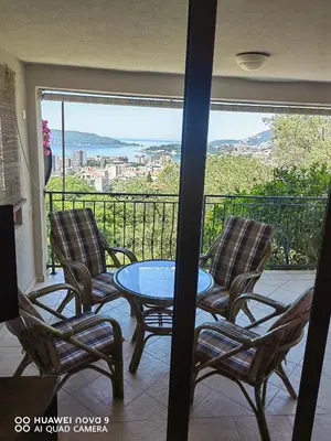 a patio with three chairs and a table and a balcony at Apartments Villa Čučuk in Budva