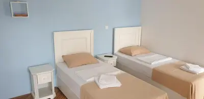 three beds in a room with blue walls at Villa Rihter in Budva