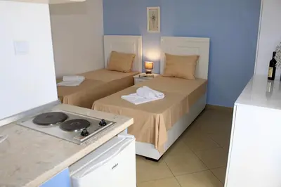 a kitchen with two beds and a stove in a room at Villa Rihter in Budva