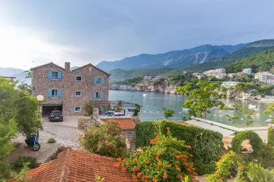 a view of a river with a building and a city at Stone Beach Apartments in Pržno