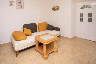 a living room with a couch and a table at Stone Beach Apartments in Pržno