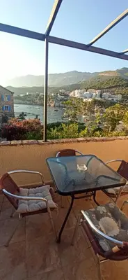 a table and chairs on a balcony with a view at Stone Beach Apartments in Pržno