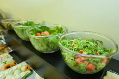 a group of salad bowls sitting on a counter at Hotel Lazaro in Podgorica