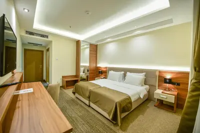 a hotel room with a bed and a desk at Hotel Lazaro in Podgorica