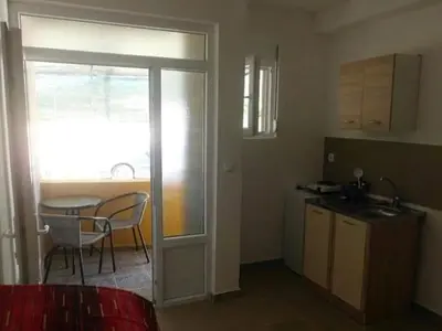 a kitchen and dining room with a table and a table and chairs at Apartmani Holiday Sutomore in Sutomore