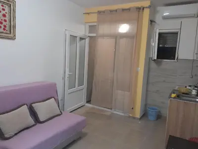 a living room with a purple couch and a sliding door at Apartmani Holiday Sutomore in Sutomore