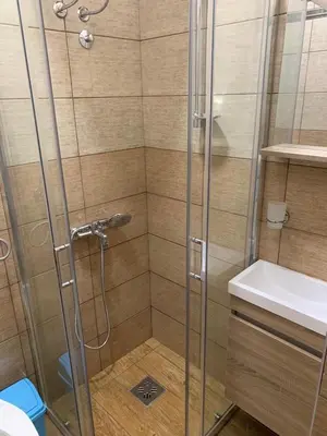 a shower with a glass door and a sink at Apartman Dacaa in Podgorica