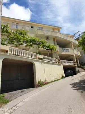 a large building with a parking garage in front of it at Apartment Dragicevic 5 with Garage in Budva