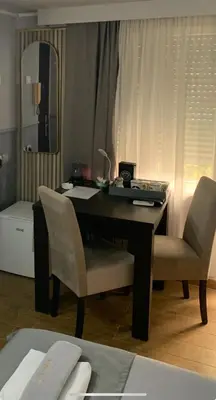 a desk with two chairs and a mirror in a room at Apartman Daca in Podgorica