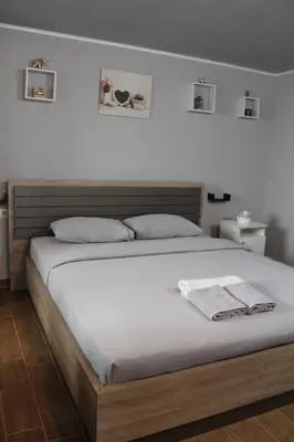 a bedroom with a large bed with two towels on it at Apartman Daca in Podgorica