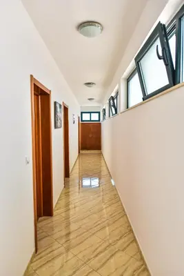 a hallway in a building with windows and wooden floors at Apartments Laguna in Ulcinj