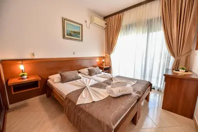 a hotel room with a large bed and a window at Apartments Laguna in Ulcinj