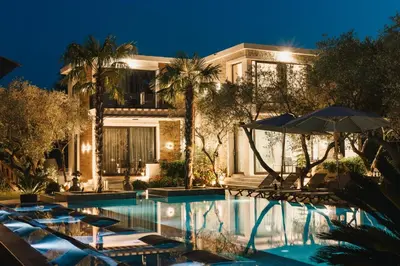 a hotel with a swimming pool with chairs and an umbrella at Giardino Lux Apartments in Ulcinj