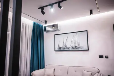 a living room with a couch and a picture of sailboats at Giardino Lux Apartments in Ulcinj
