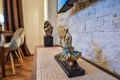 a table with a statue on top of it next to a brick wall at Giardino Lux Apartments in Ulcinj